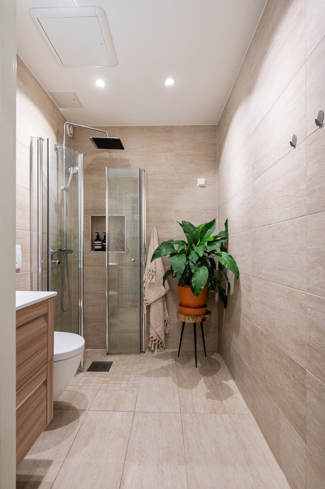 Innredningen består av vegghengt toalett, servant med innredning, speilskap med lys over servant og dusjhjørne med svingbare glassdører. Galleribilde