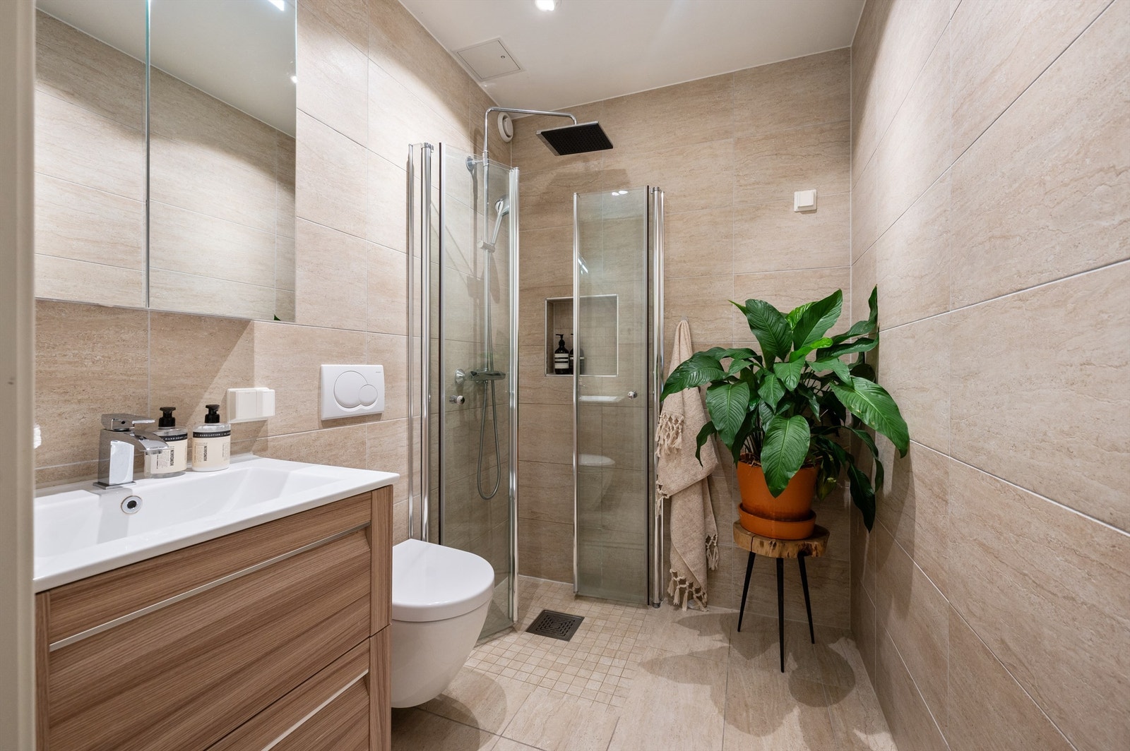 Delikat og lekkert flislagt baderom med gulvvarme og downlights i himlingen. Badet ligger i 2. etasje. Galleribilde