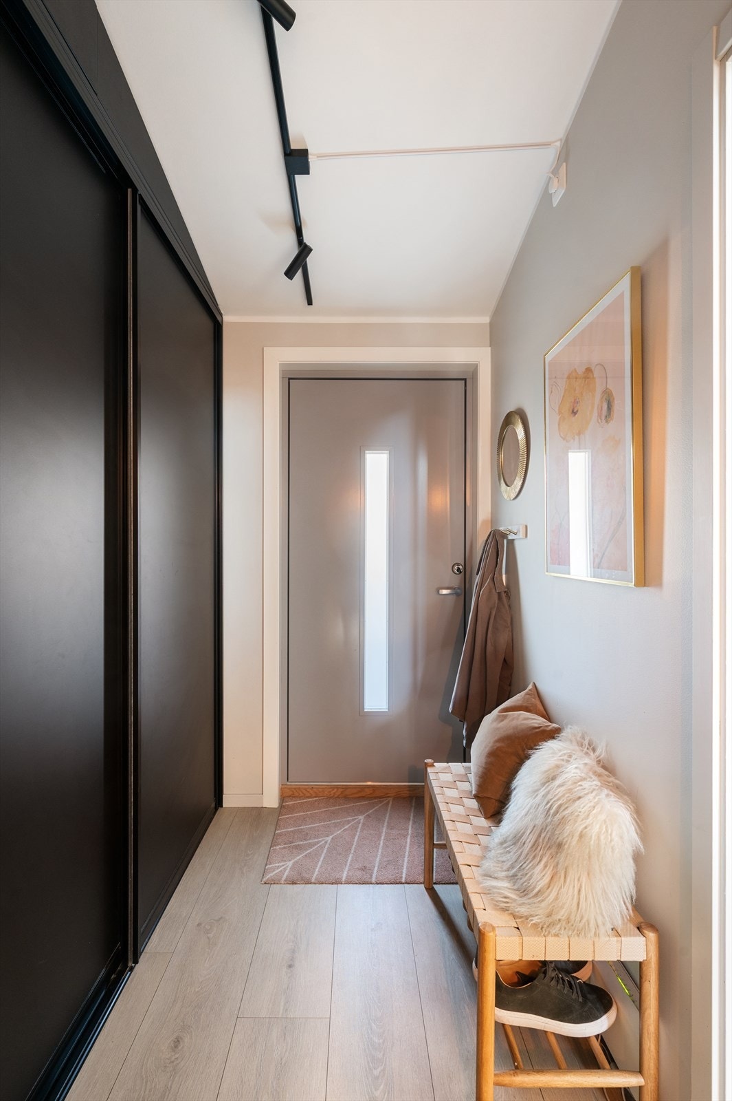 Det er god plass til å henge fra seg klær og sette fra seg skotøy i skyvedørsgarderobe. Videre adkomst til kjøkken, wc-rom og trapp ned til 2. etasje. Galleribilde