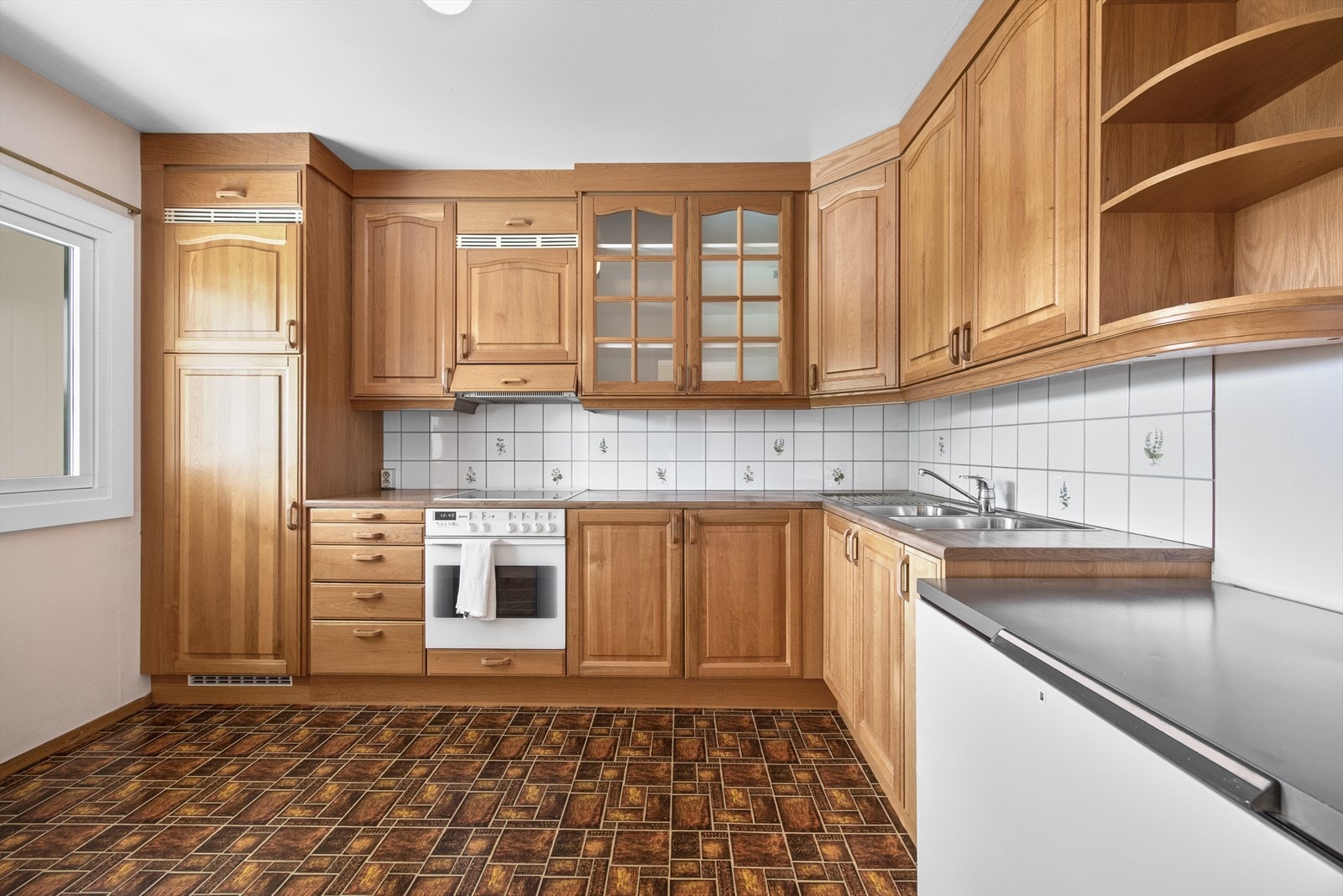 Kjøkkenet har en praktisk L-form som gir godt med benkeplass Galleribilde