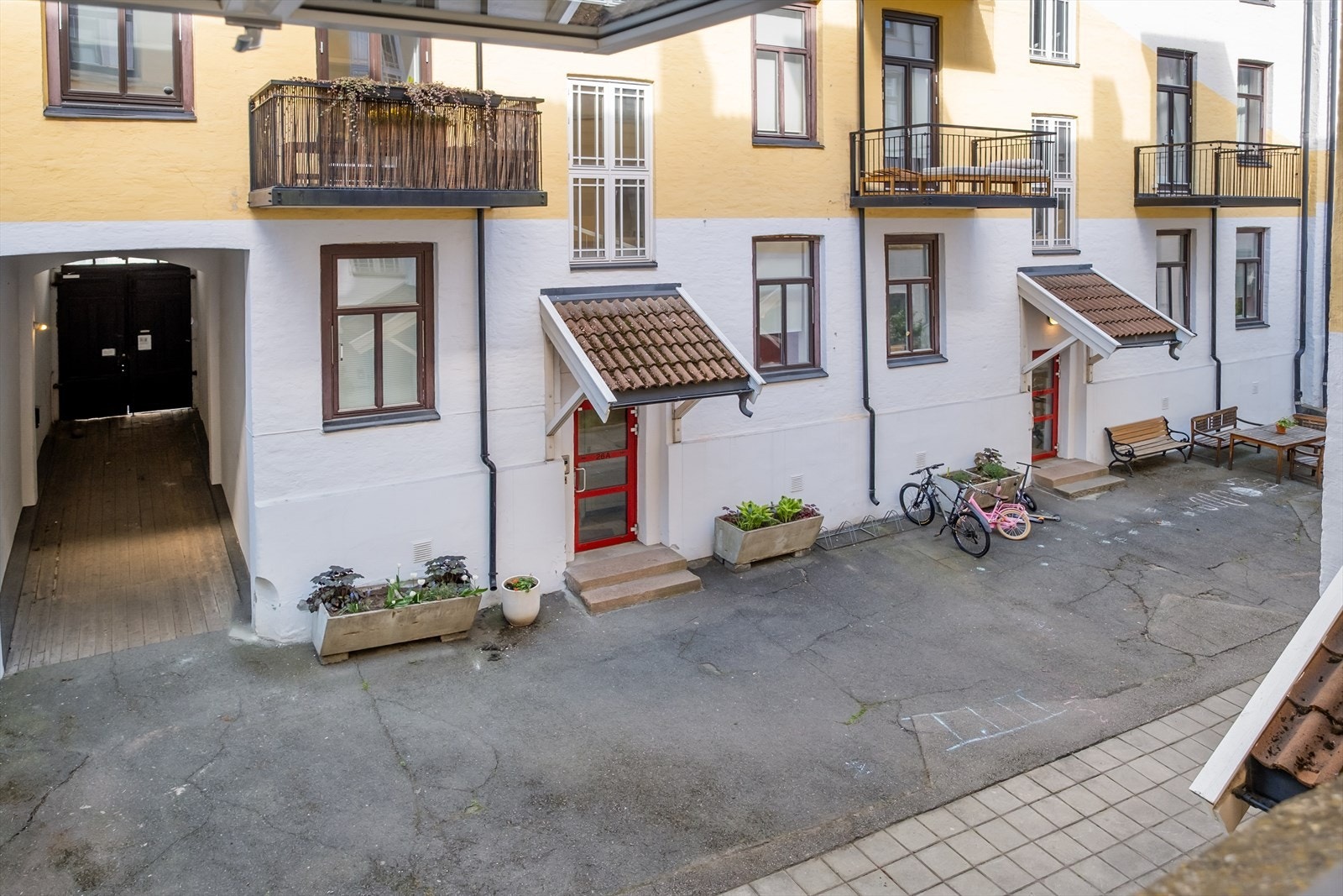 Pent gårdsrom med beplantning og sykkelparkering. Galleribilde