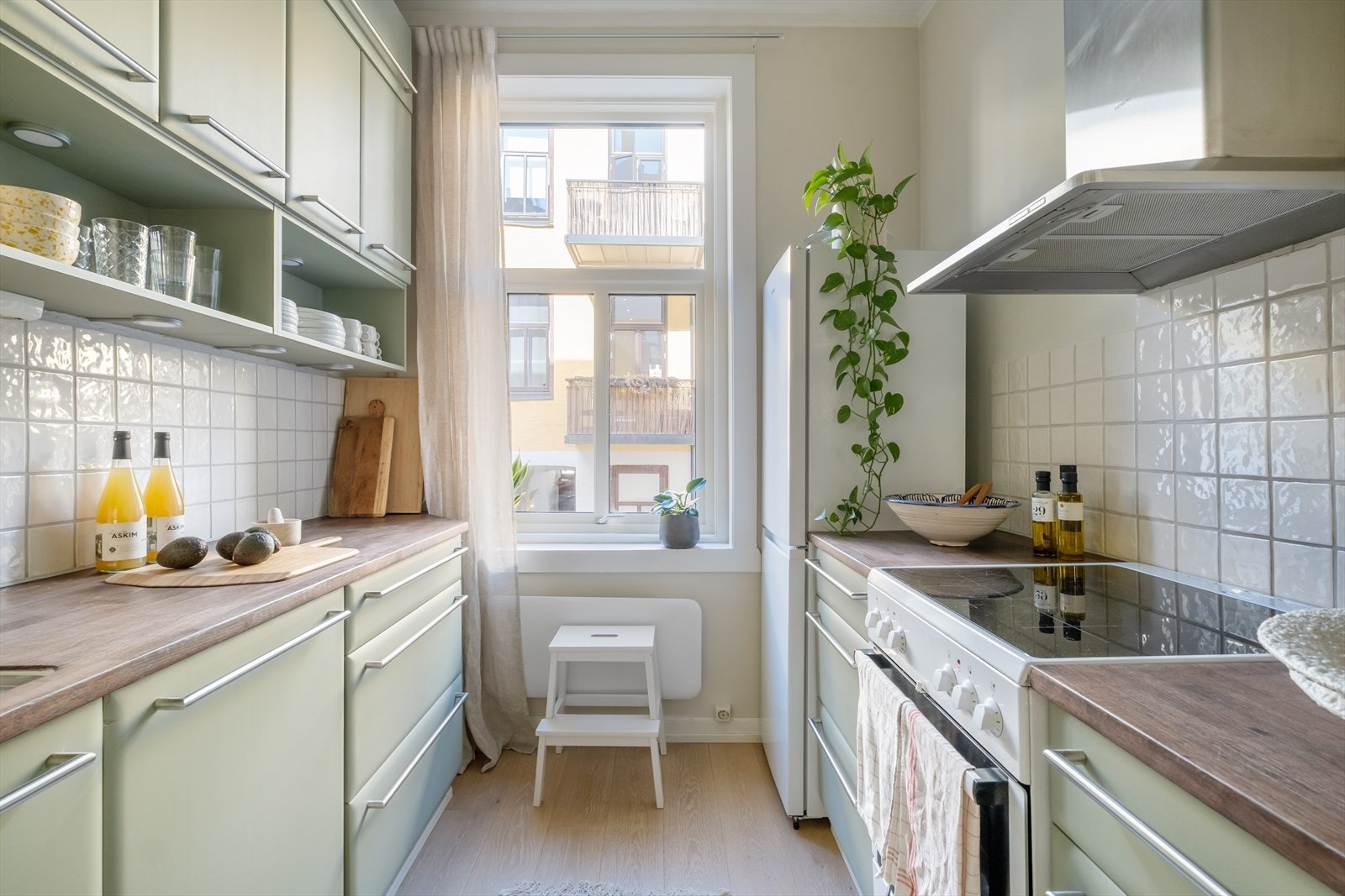 Kjøkkeninnredning med glatte fronter og heltre benkeplate med nedfelt vask- og skyllekum. Integrert oppvaskmaskin. Kullfilterventilator over kokeplass. Galleribilde