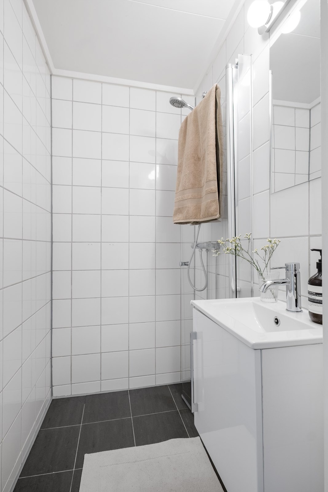 Flislagt baderom med varme i gulvet. Baderommet er innredet med servant nedfelt i innredning og dusjhjørne med svingbar glassvegg. Elektrisk styrt vifte. Galleribilde