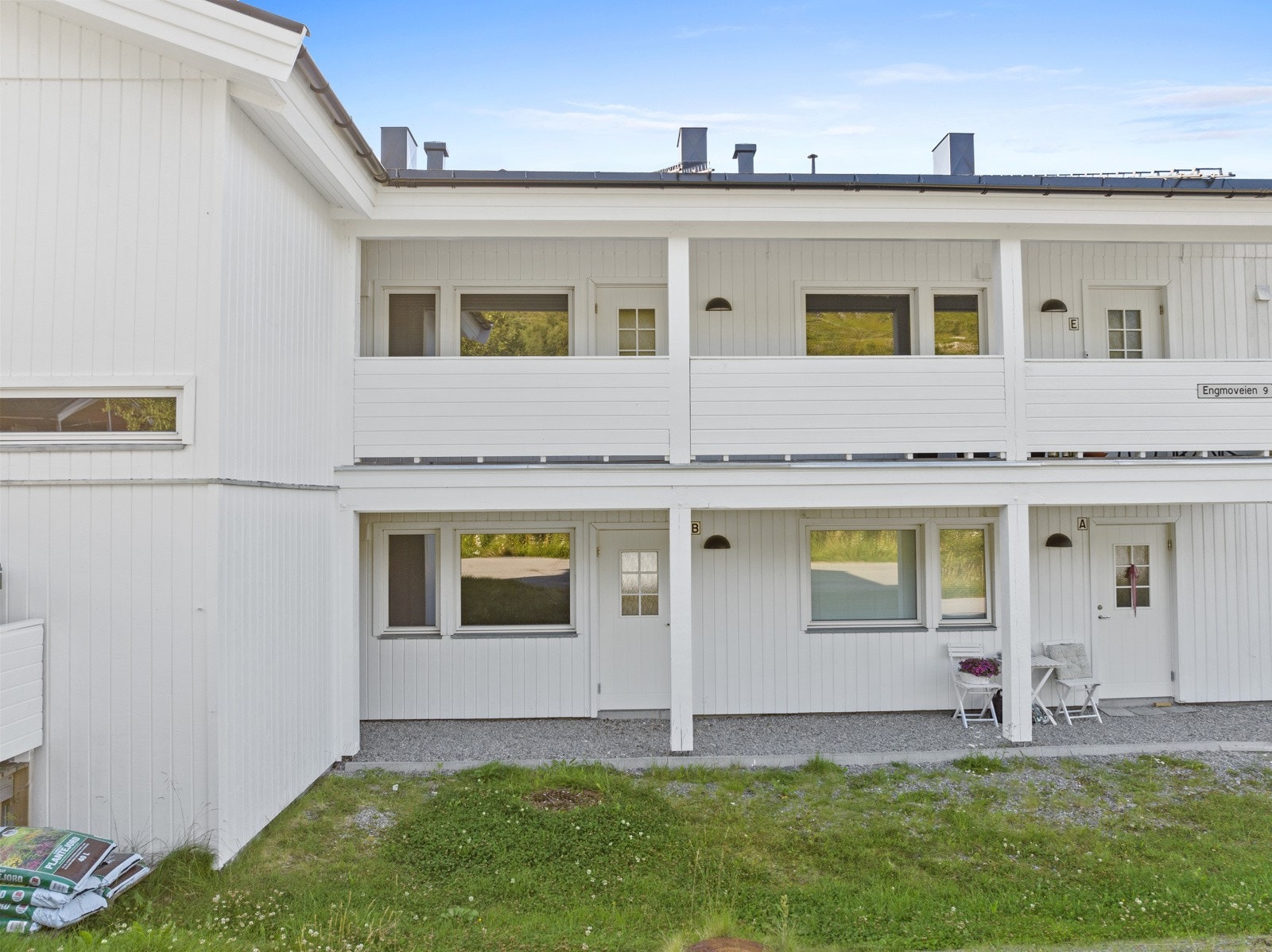 Boligen ligger i midten av en rekke i nederste etasje, med et praktisk overbygg som skjermer mot vær og vind. Galleribilde