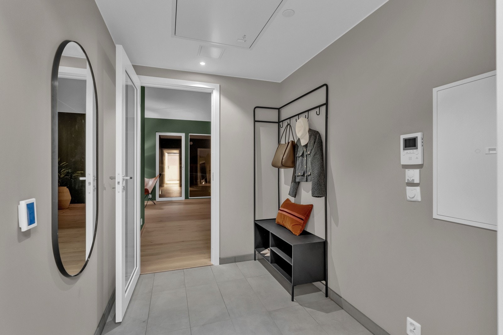 Velkommen inn i en lys og innbydende entré malt i en lun beige nyanse. Det gråtonede flisgulvet gir et stilrent uttrykk, og med vannbåren gulvvarme er komforten ivaretatt Galleribilde