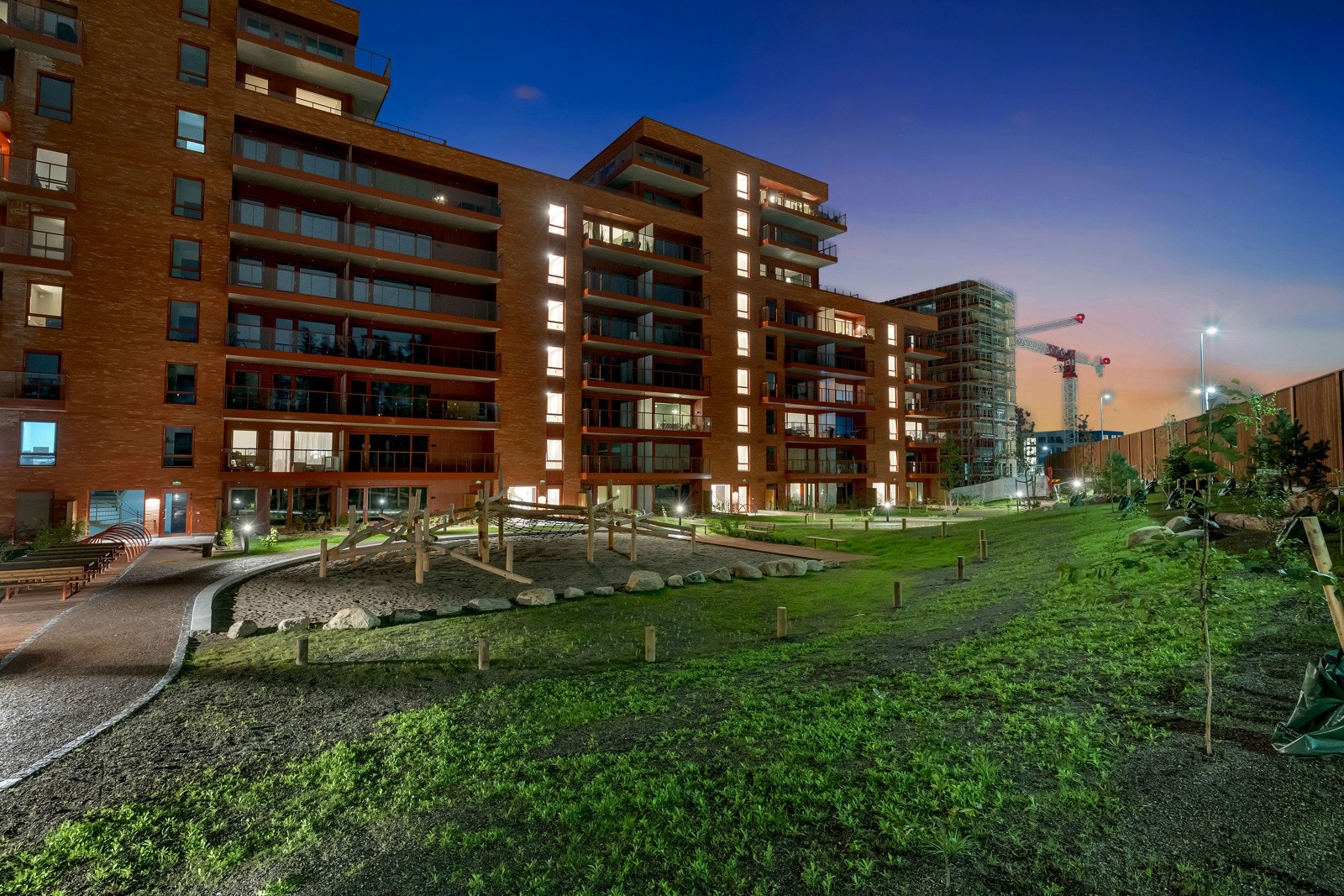 Fellesarealene er pent opparbeidet med gruset gangvei, plen, prydbusker, benker og lekeapparater Galleribilde