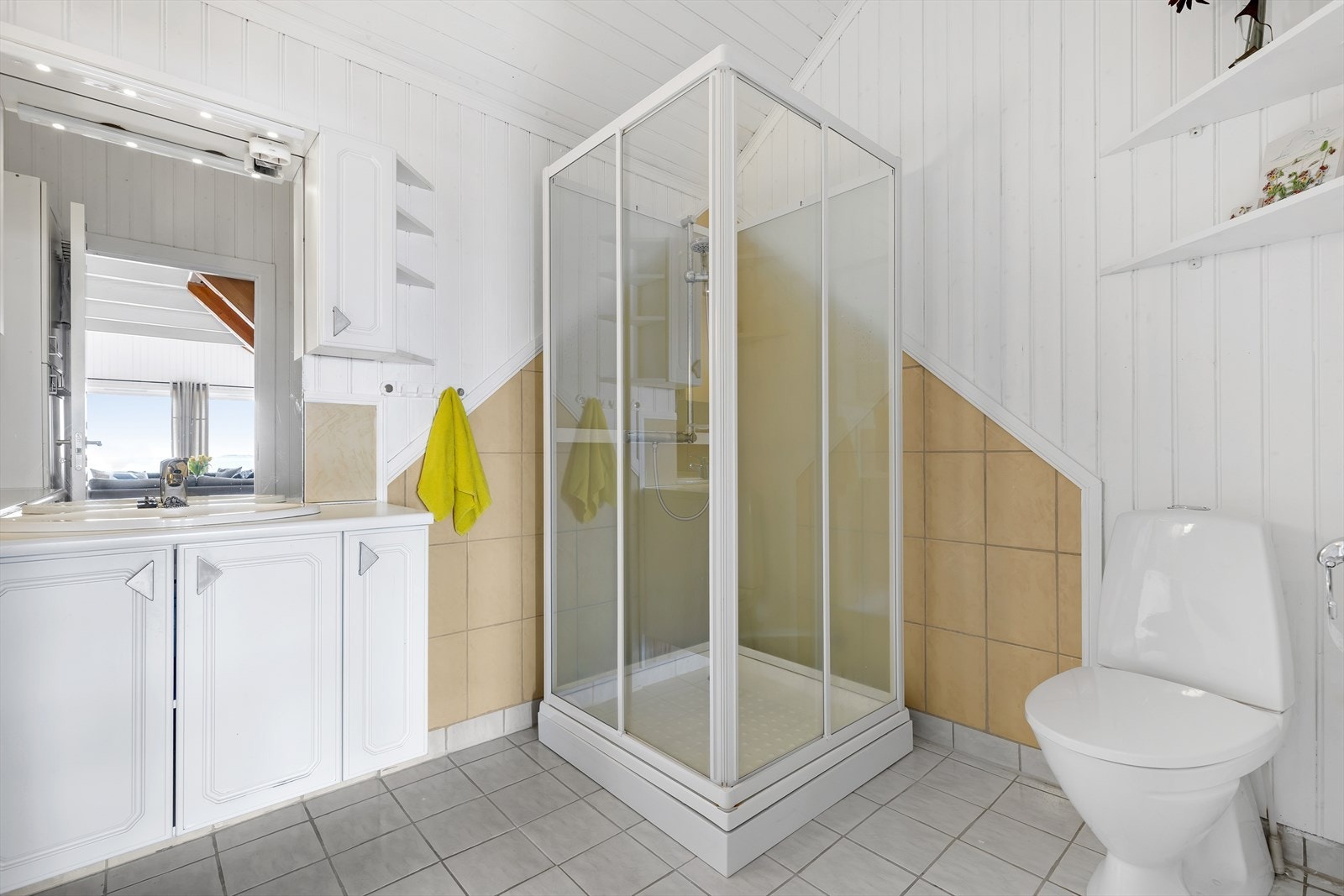 Badet er på 5,9 kvm med varmekabler i flislagt gulv. Badet er innredet med toalett av nyere dato, servant, dusjkabinett, samt opplegg for vaskemaskin. Galleribilde