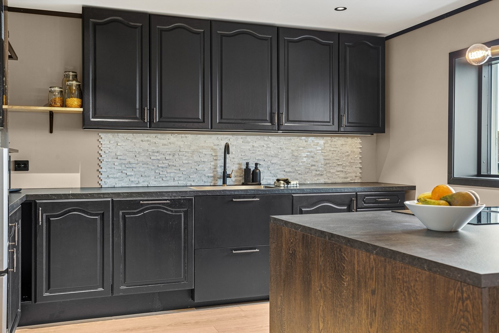 Kjøkkenet utnytter benk- og skapplass godt, med et flott design. Galleribilde