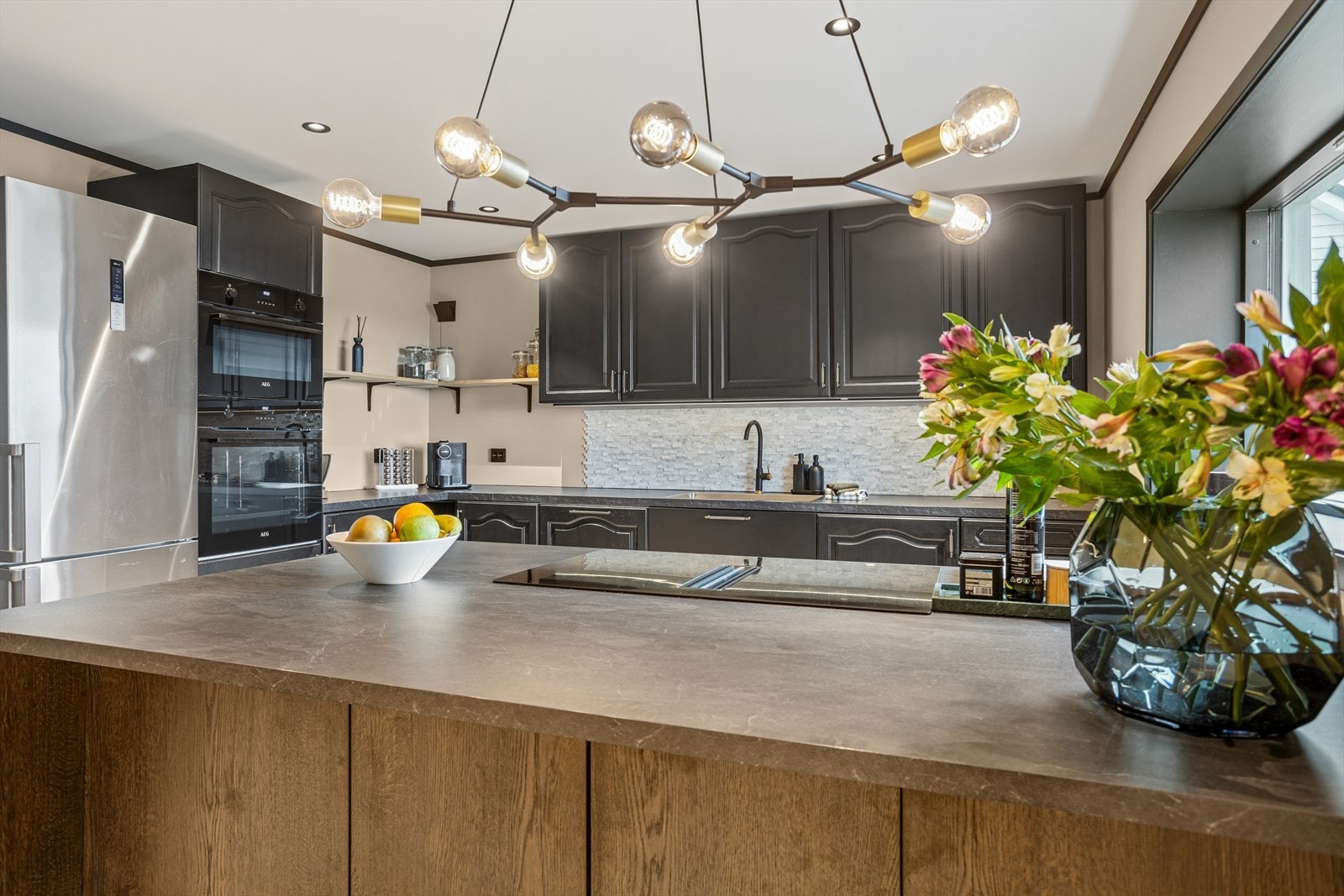 Kjøkkenet er utstyrt med profilerte fronter, nymalt i 2023, og en laminat benkeplate. Den flotte kjøkkenøyen, med sine glatte overflater, ble montert i 2023 og tilfører kjøkkenet et stilrent og funksjonelt preg. Galleribilde