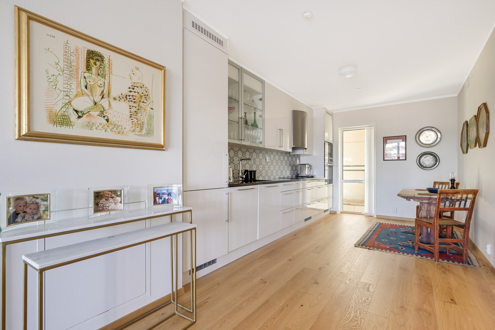 Kjøkkenet er lyst med glatte fronter og benkeplate av stein. Galleribilde