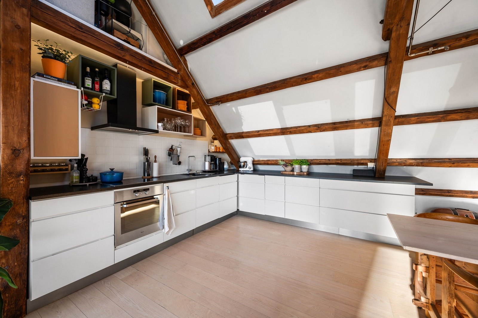 Lyst og fint kjøkken med tidløst uttrykk og godt med skap- og benkeplass. Det er lagt fliser over benkeplaten. Galleribilde