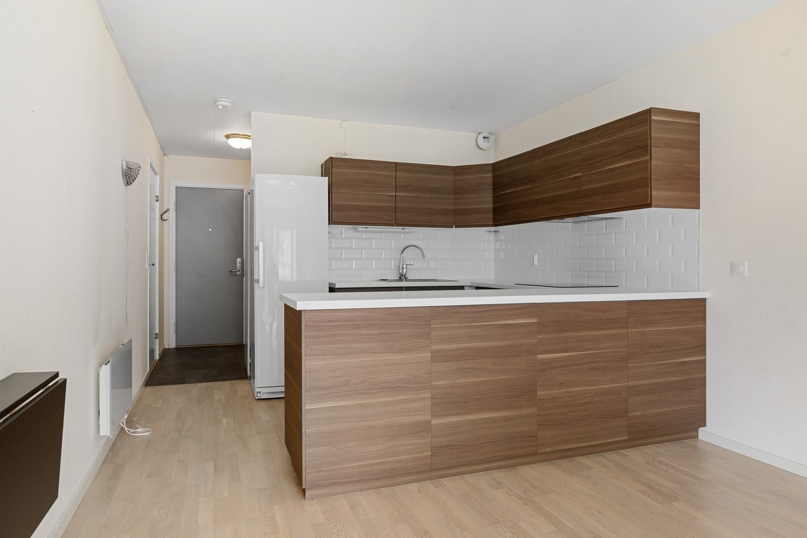 Flott kjøkken fra 2017 i åpen løsning med laminatgulv og tapet på vegger. Fliser over kjøkkenbenk. Kjøkkeninnredning med medfølgende hvitevarer (Komfyr, platetopp, oppvaskmaskin og kjøleskap. I tillegg medfølger eget fryseskap i gangen Galleribilde