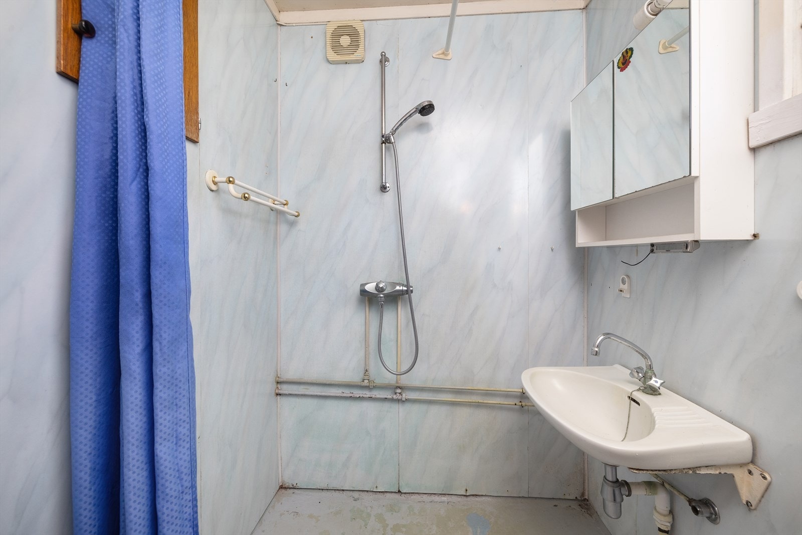 Det er montert åpen hjørnedusj og servant. Galleribilde