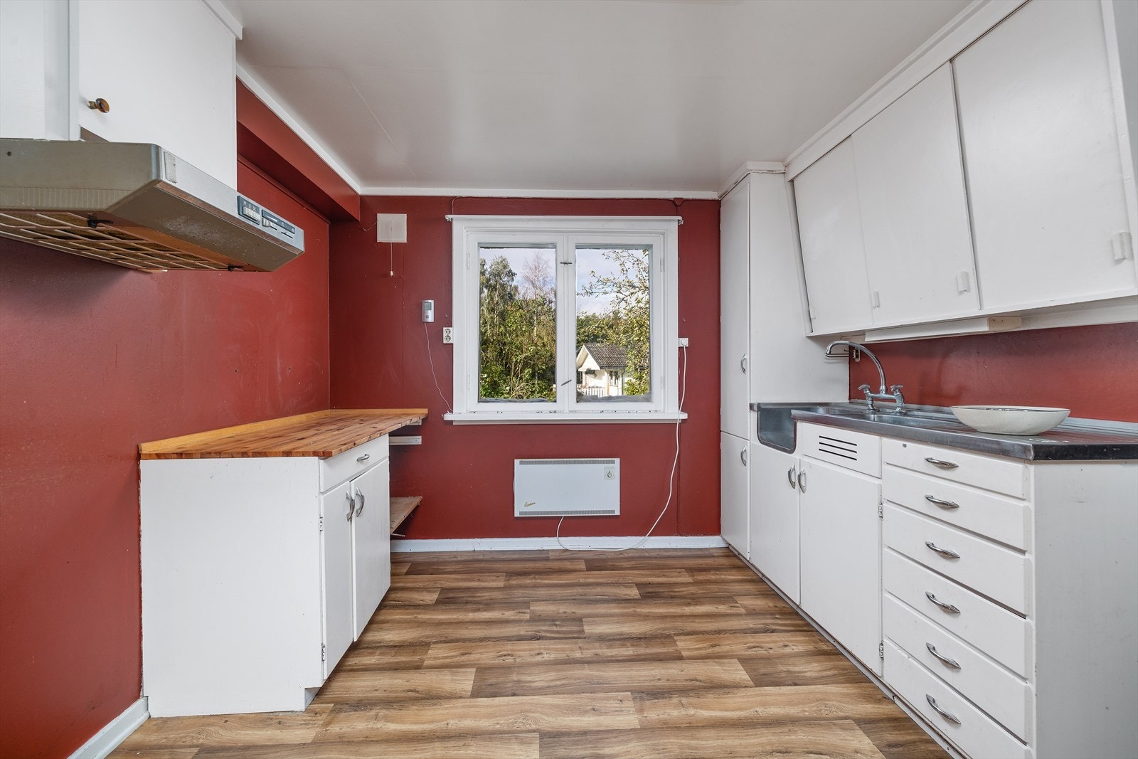 Kjøkkeninnredning med malte slette fronter. Stål benkebeslag og benkeplate i furu. Galleribilde