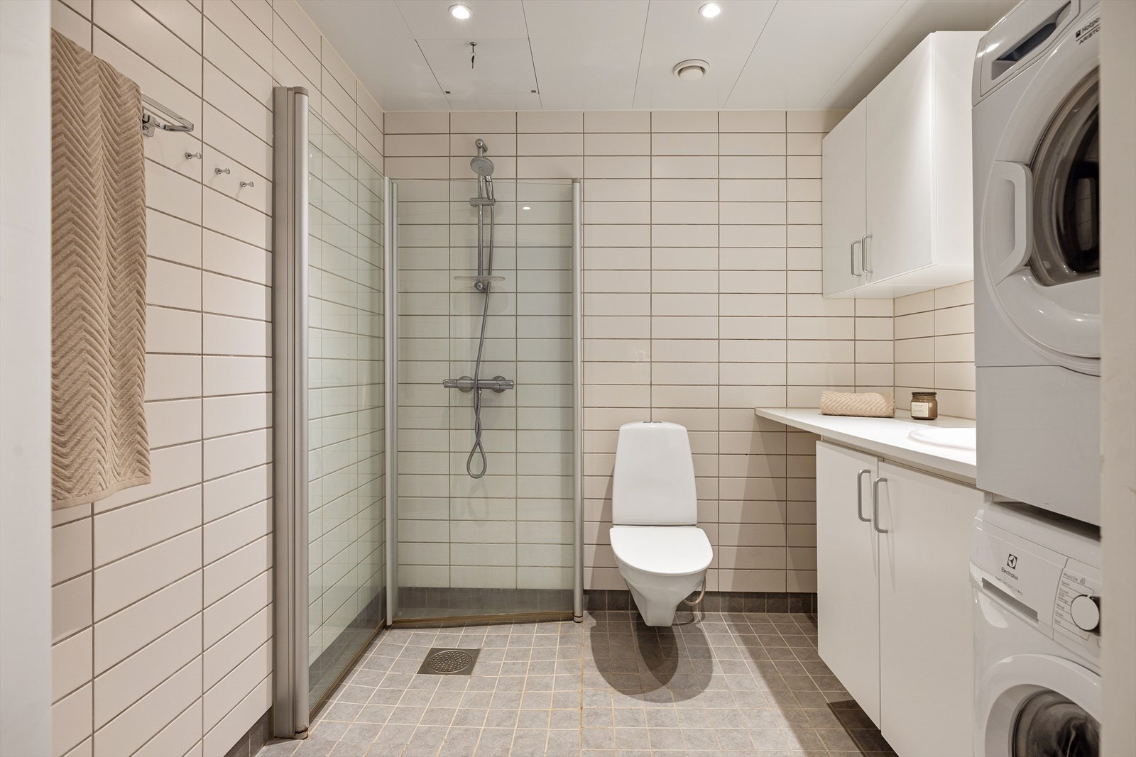 Hybeldelen har et flislagt bad med en stilren servantinnredning og glatte hvite fronter. Galleribilde