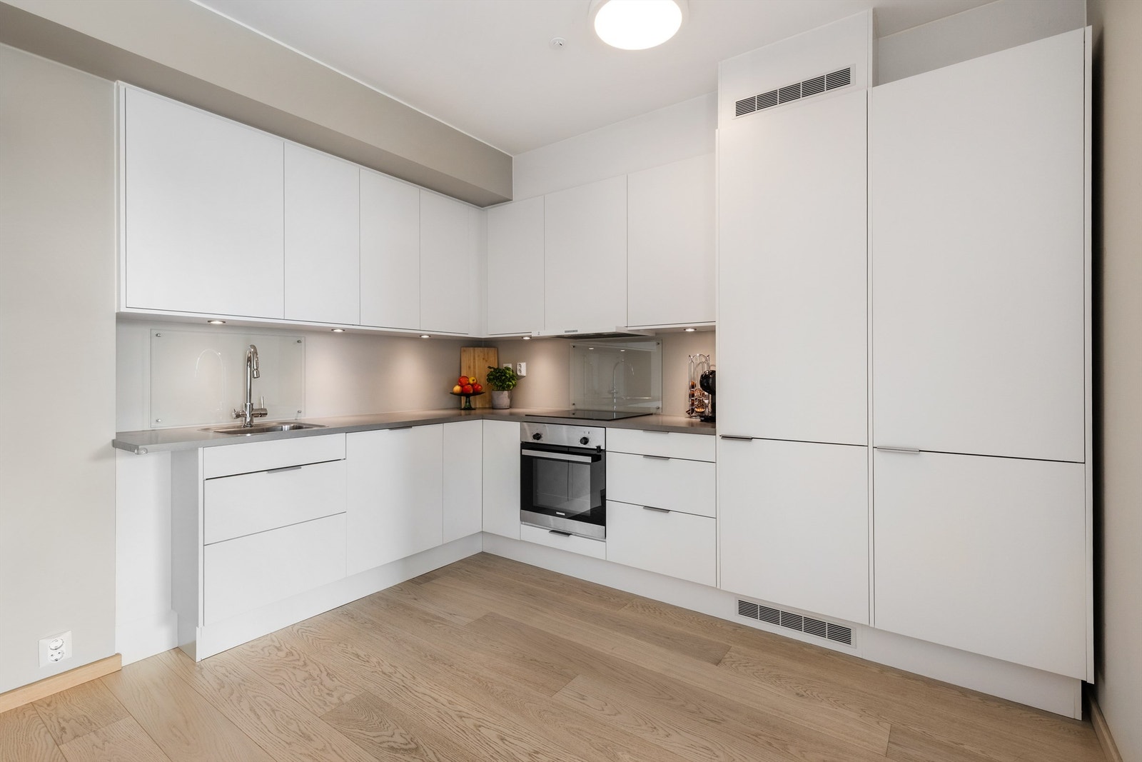 Det er belysning over benkeplate, og av integrerte hvitevarer er det induksjonstopp, stekeovn, oppvaskmaskin og kjøleskap med frysedel. Galleribilde