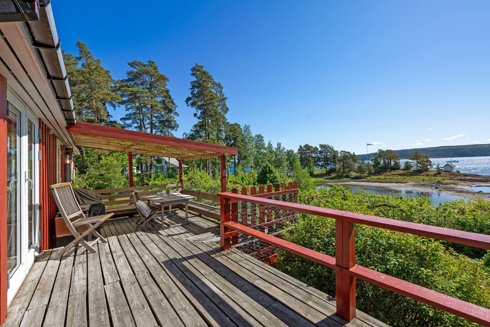 Stor delvis overbygget terrasse utenfor stuen med nydelig utsikt. Galleribilde