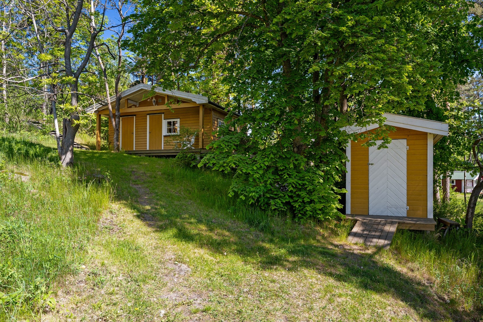 Annekset og én av to boder ligger rett bortenfor den gule hytten. Galleribilde