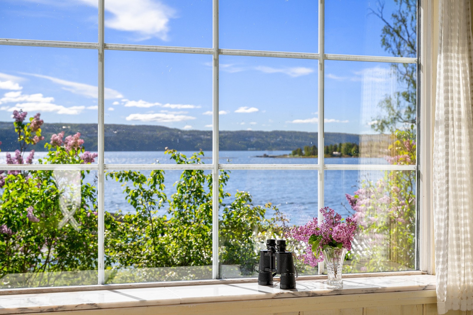 Den gule hytten har godt med naturlig lysinnslipp via mange store vinduer og glassdører. Galleribilde