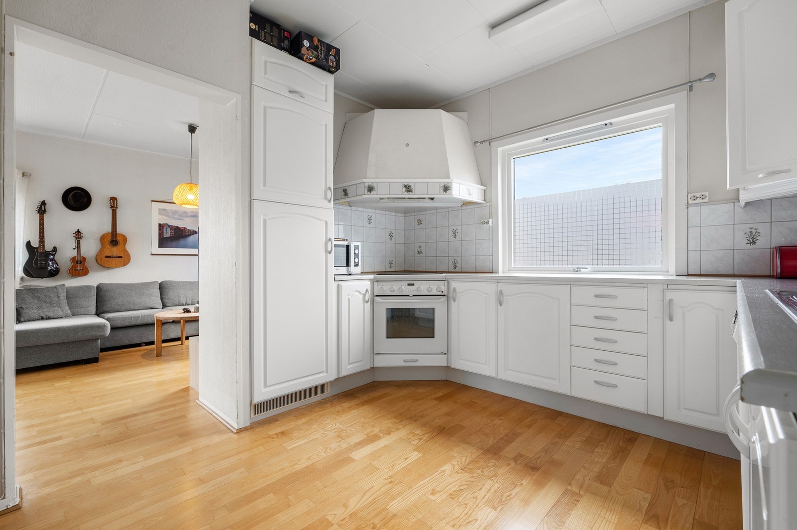 Kjøkkeninnredning med hvite, profilerte fronter og benkeplate av laminat Galleribilde