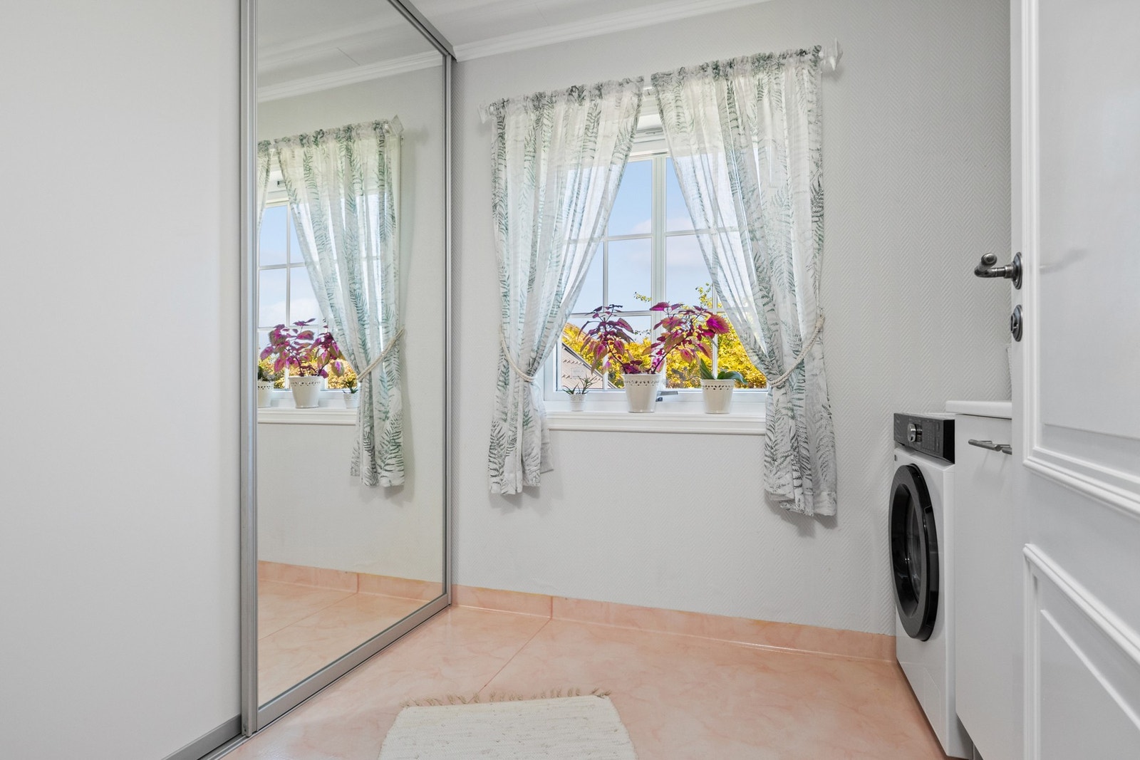 Eget praktisk vaskerom med skyvedørsgarderobe Galleribilde