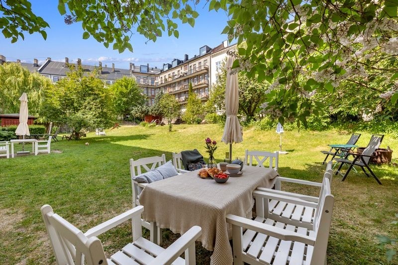 Frodig bakgård med flere sittegrupper Galleribilde