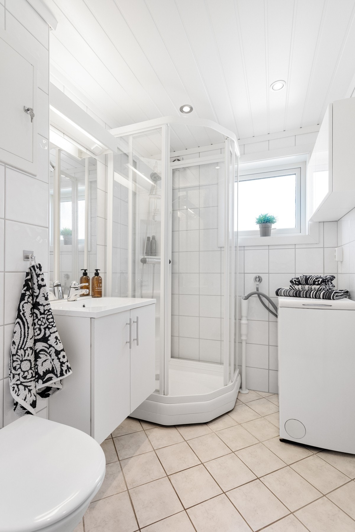 Baderom oppusset i regi av borettslaget i ca 2007. Badet inneholder dusjkabinett, toalett, innredning med servant og opplegg til vaskemaskin. Flislagte overflater. Galleribilde