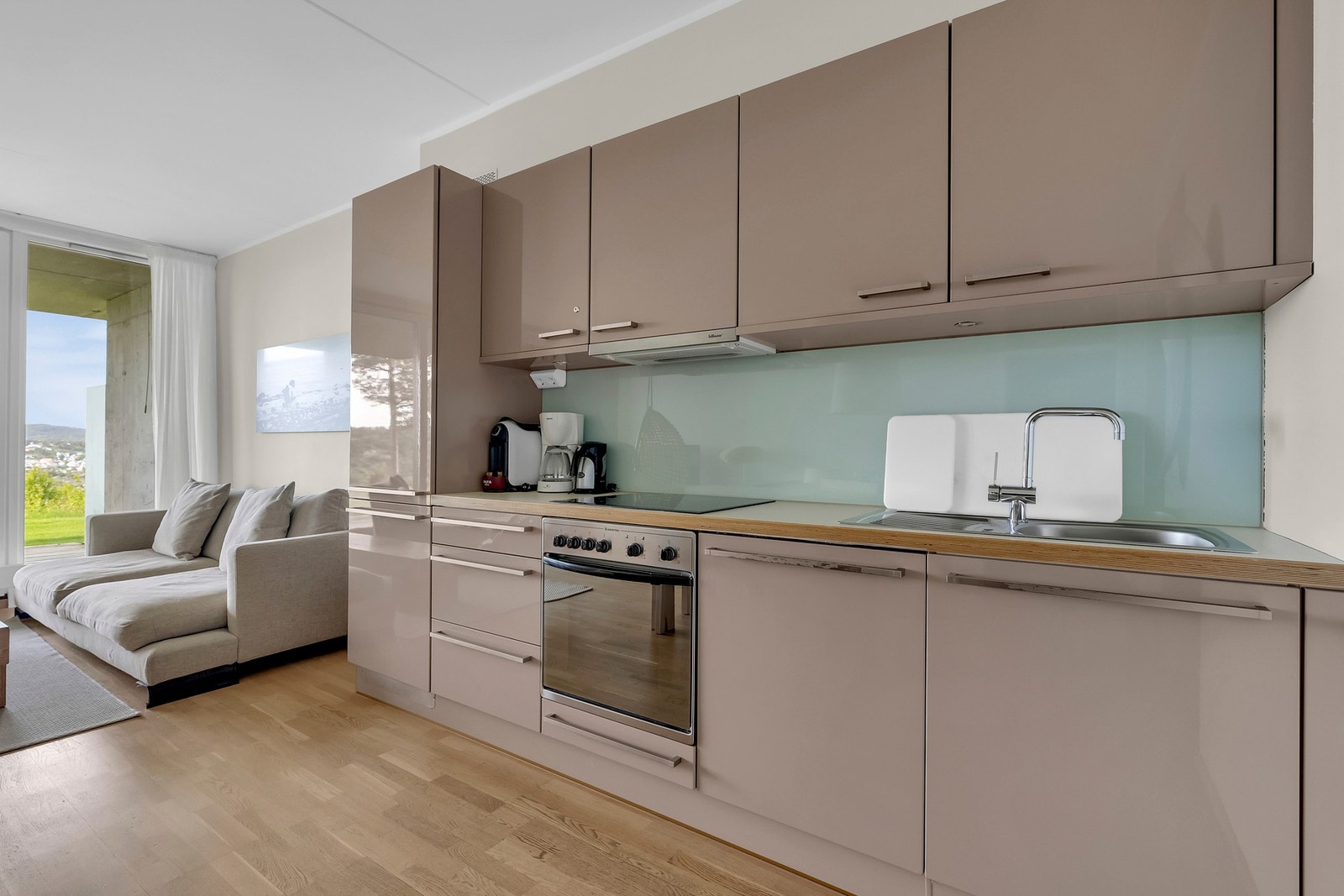 Her finner du kjøle- og fryseskap, komfyr og oppvaskmaskin - alt pent tilpasset for et strømlinjeformet uttrykk. Galleribilde