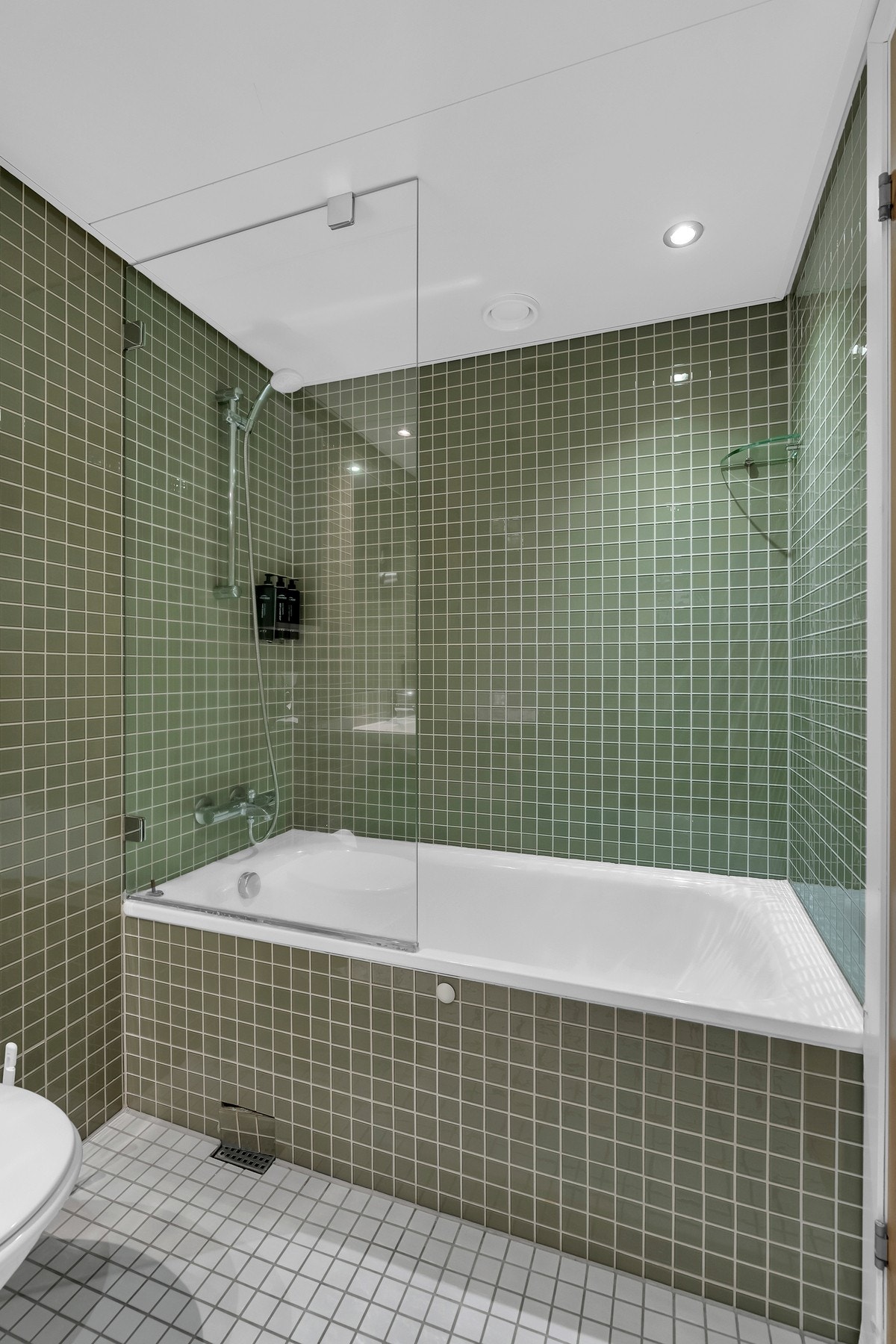 Baderomsinnredning fra Grohe med speil elegant innfelt i flisveggen. Galleribilde