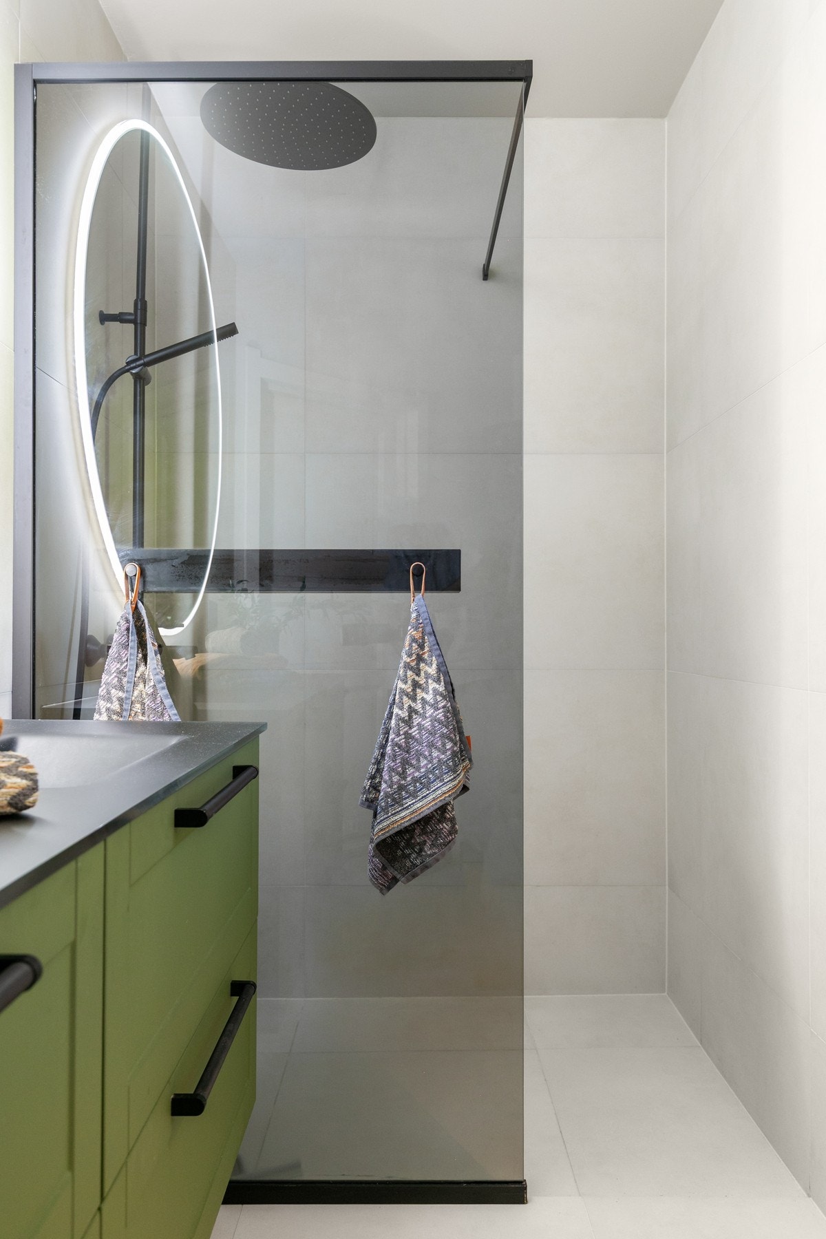 Sorte detaljer skaper en rød tråd på badet. Innbydende regnfallsdusj bak fastmontert glassdør fra Halvor Bakke. Galleribilde