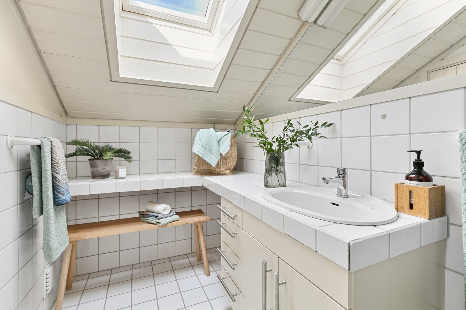 Videre har etasjen et flislagt baderom med mye lys fra takvinduet. Galleribilde