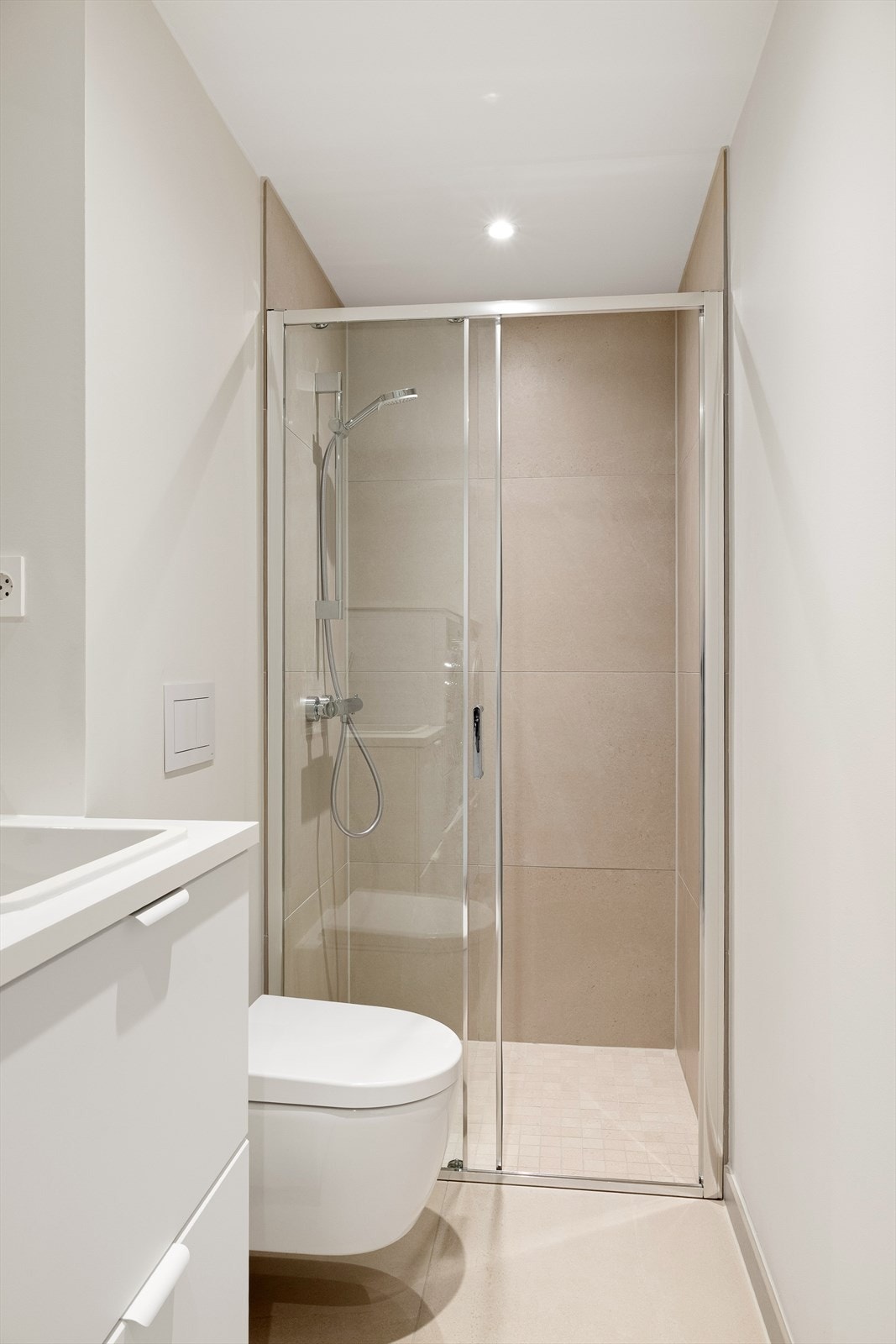 Badet har fliser på gulv og i dusjsone. Det er varmekabler i gulv og downlights i himling. Galleribilde