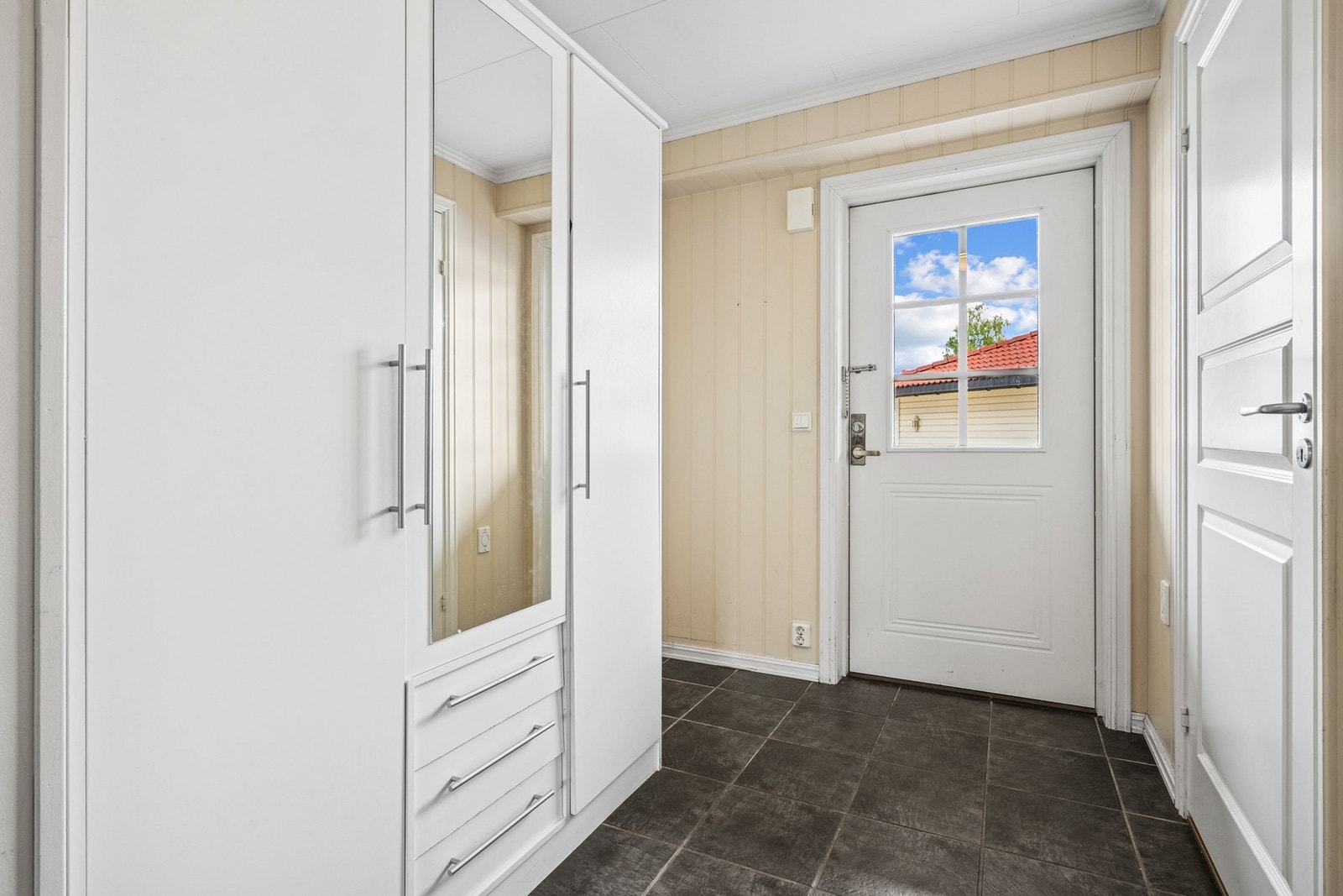 Romslig entré med flislagt gulv, praktisk for av å påkledning. Galleribilde
