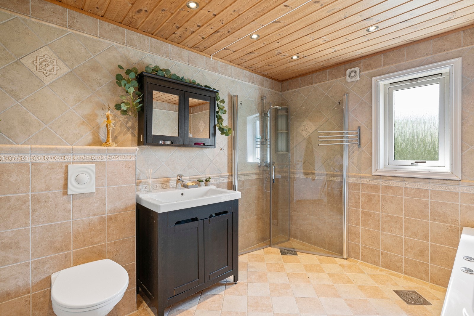 Badet inneholder heldekkende servant med underskap, speilskap, 2 sideskap, wc, boblebad og dusjhjørne Galleribilde