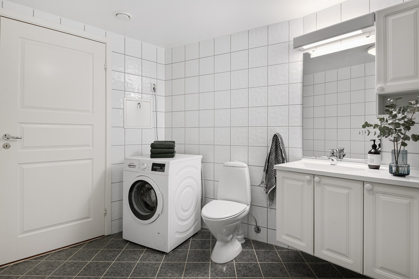 Badet er innredet med baderomsinnredning med servant, toalett, dusjkabinett og opplegg for vaskemaskin. Galleribilde