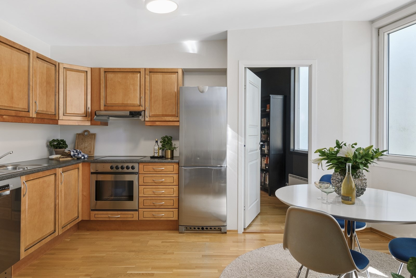 Kjøkkeninnredning med profilerte fronter, laminert benkeplate, oppvaskkum i stål, ventilator over keramisk topp og integrert komfyr. Galleribilde