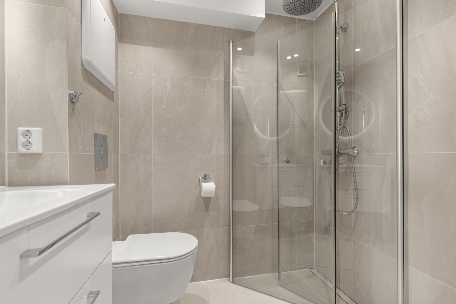 Badet er utstyrt med servantinnredning med helstøpt servant, vegghengt toalett og dusjhjørne med svingbare glassdører. Galleribilde