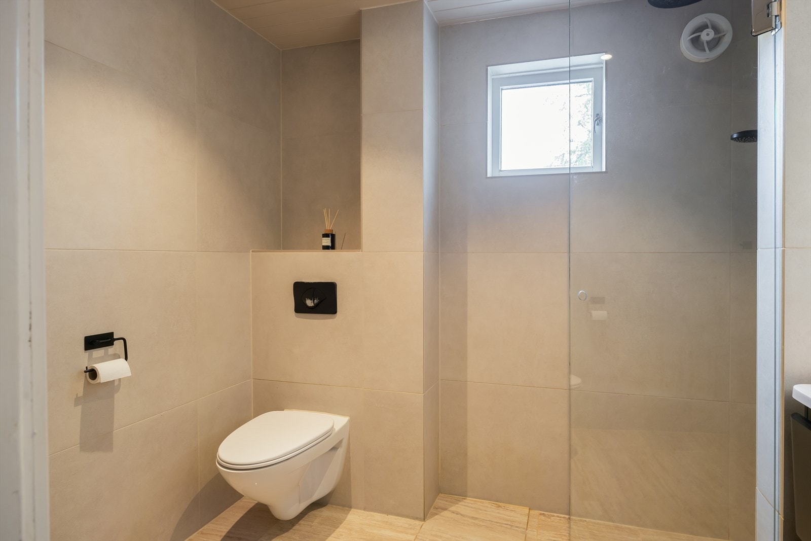 Badet er utstyrt med blant annet gulvvarme, vegghengt toalett, speil med integrert belysning og dusjnisje med regnfallsdusj og praktiske innebygde hyller. Galleribilde