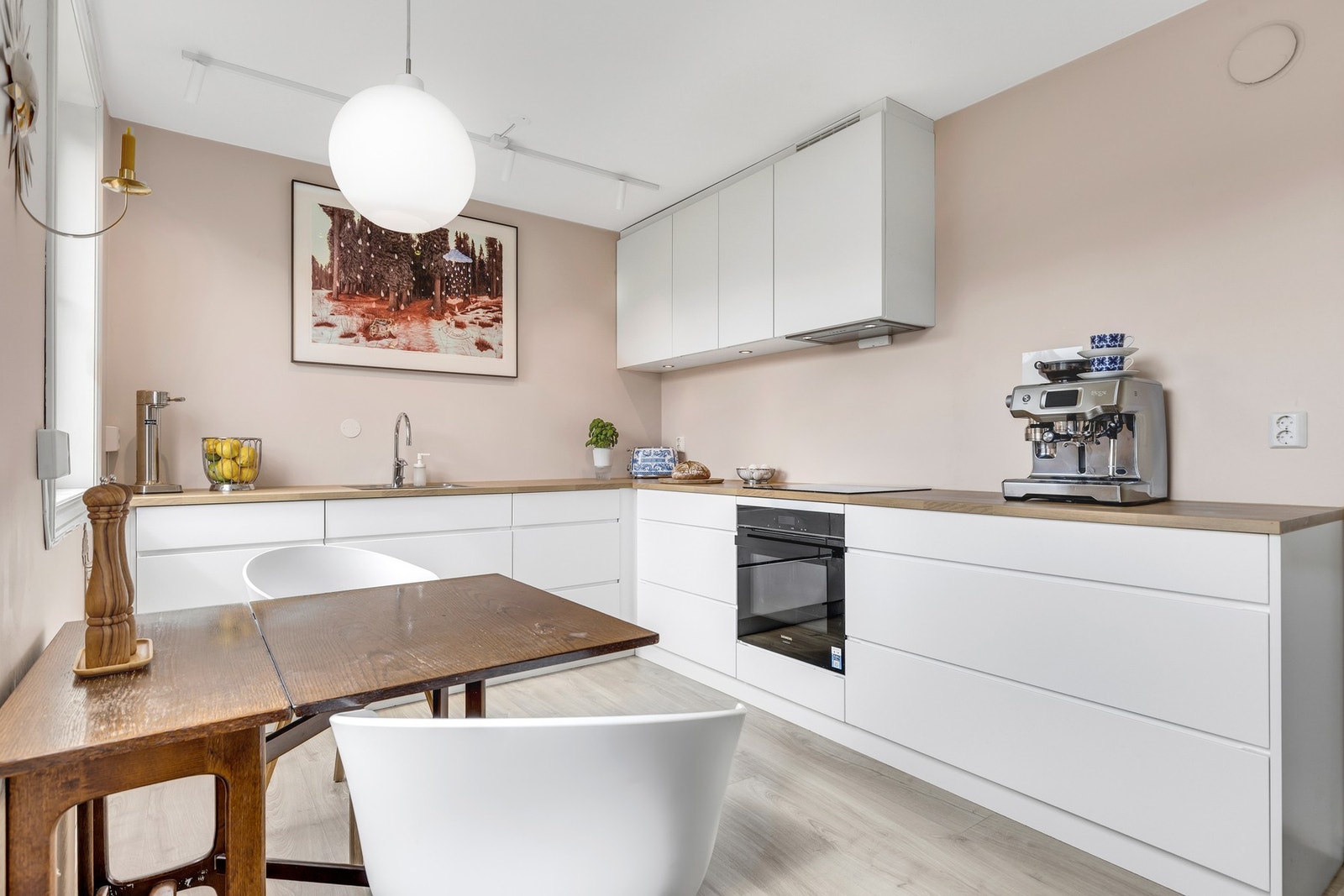 Kjøkkeninnredningen har
plane fronter i lakkert utførelse. Laminert benkeplate med nedfelt oppvaskkum i metall. Galleribilde