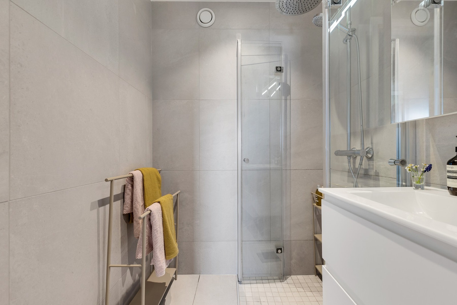 Meget pent flislagt bad fra 2022. Rommet er innredet med dusjhjørne med foldedører i glass samt veggmontert blandebatteri og dusjgarnityr. Galleribilde