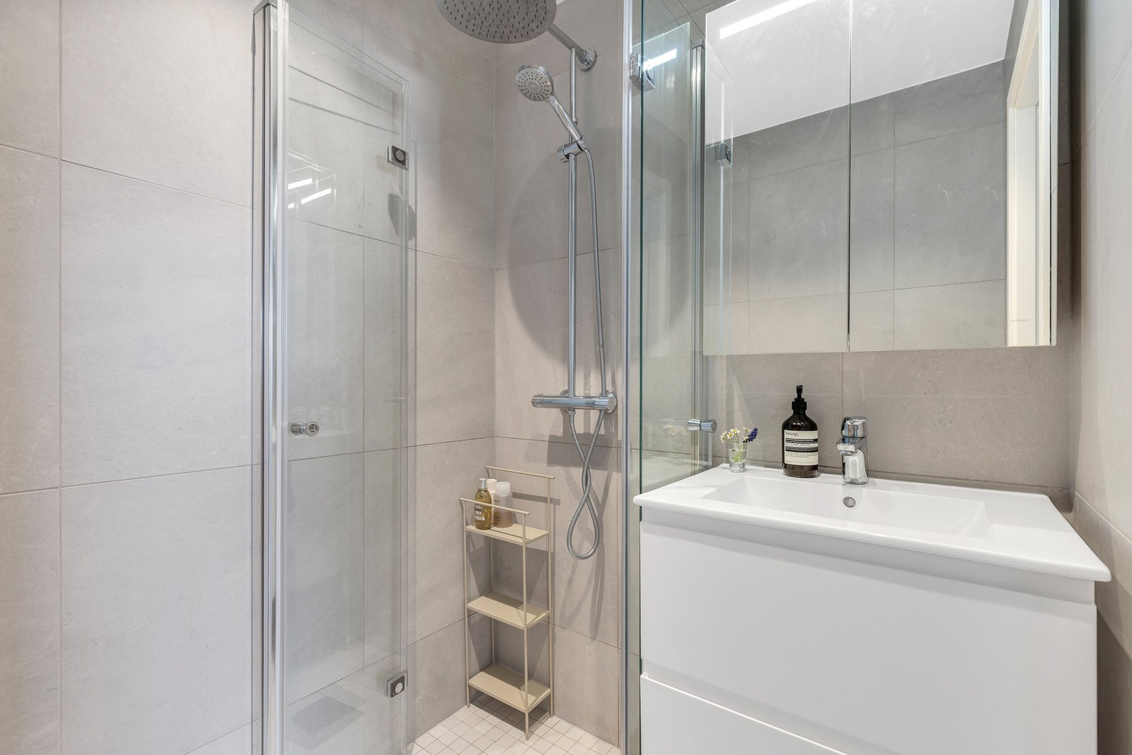 På badet er det gulvvarme som varmekilde. Servantinnredning med glatte fronter i lakkert utførelse. Galleribilde