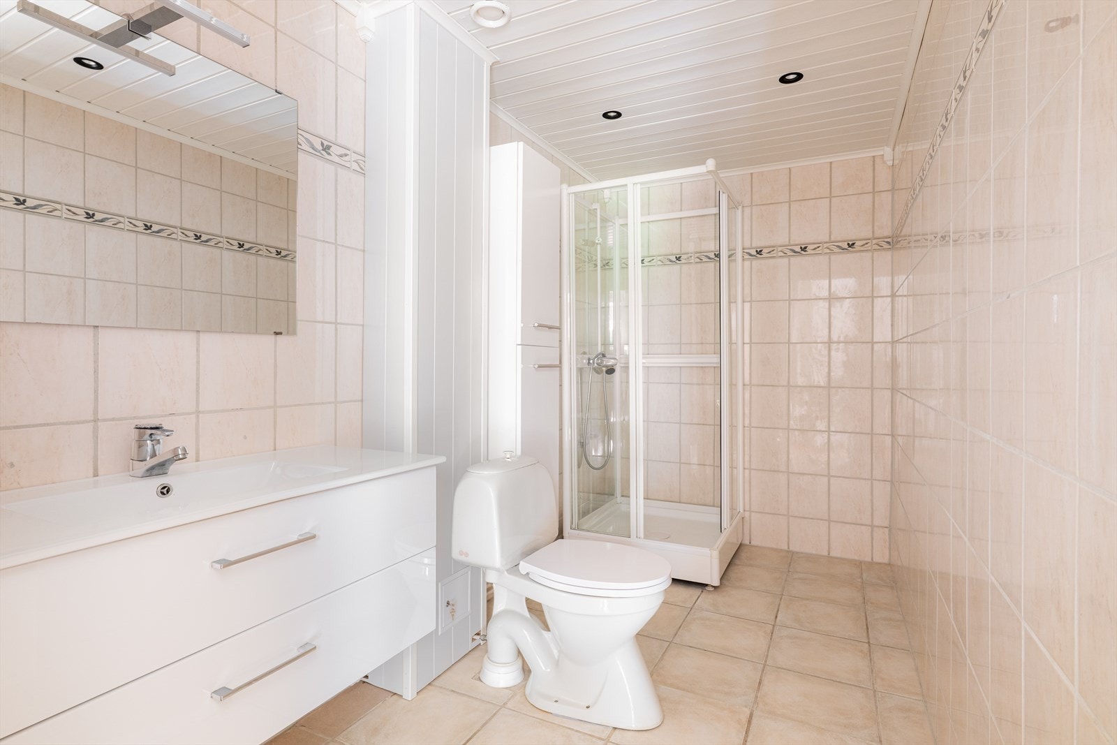 Flislagt bad med dusjkabinett, toalett og innredning med heldekkende hvit vask, underskuffer med slette fronter og speil. Høyskap med ekstra oppbevaringsplass. Naturlig ventilasjon. Borettslaget er i gang med baderoms- og ventilasjonsrehabilitering. Galleribilde