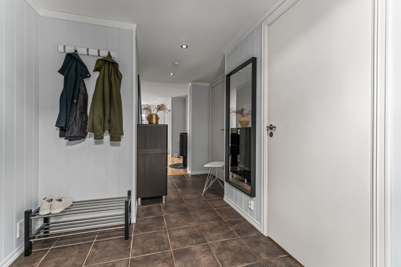 Gangen har flislagt gulv med varme og plass til yttertøy, sko etc. Galleribilde