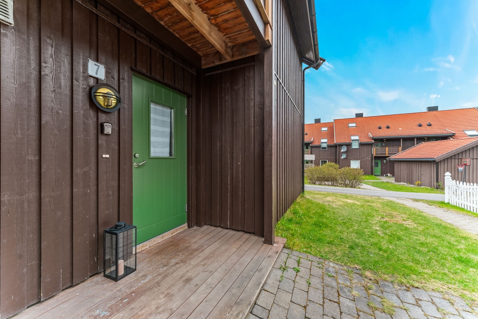 Leiligheten har adkomst på baksiden av bygget. Brosteinsbelagt adkomst og overbygget inngangsparti Galleribilde