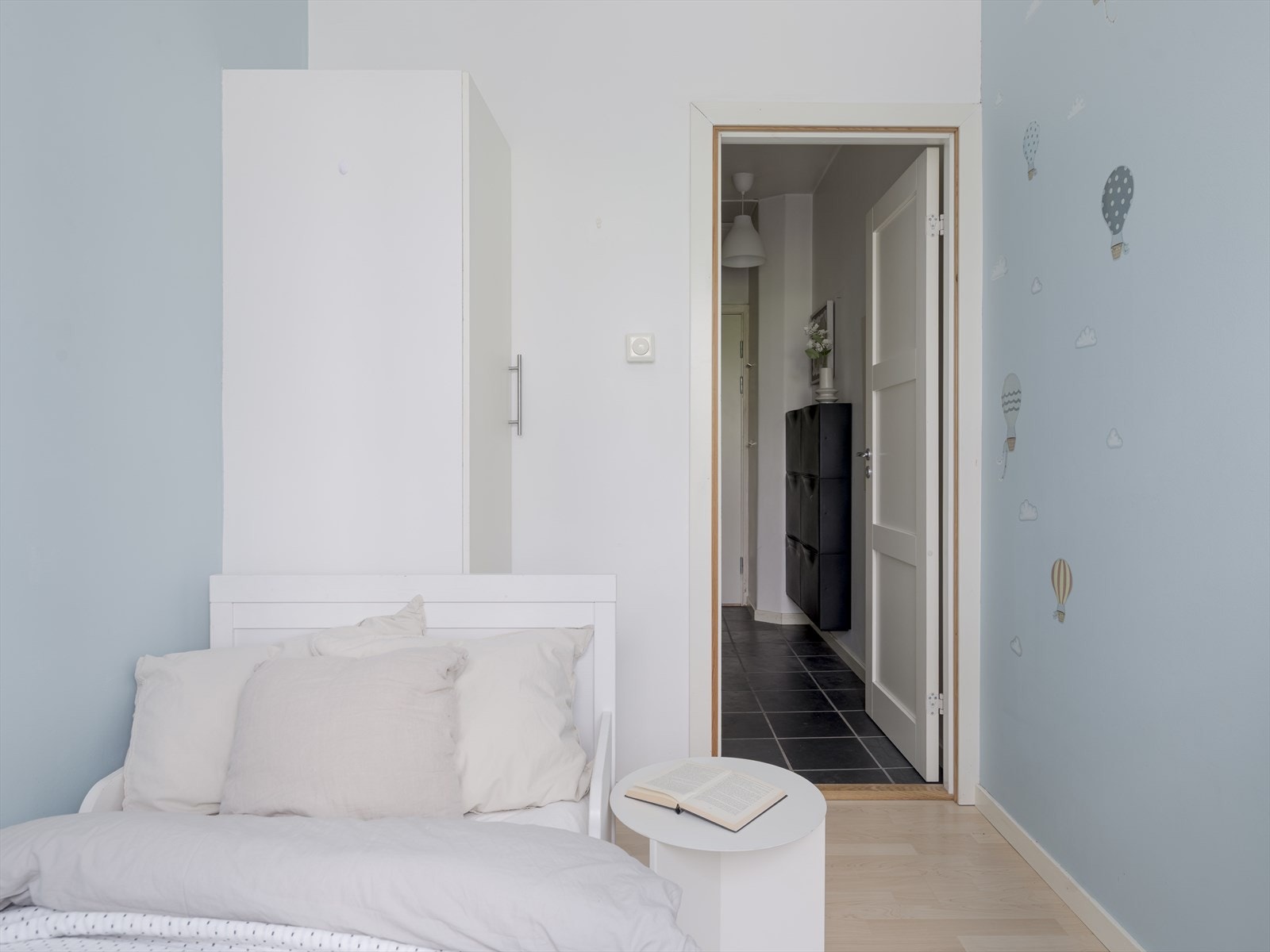 Rommet er malt i en dus og koselig blåfarge, med laminatgulv Galleribilde