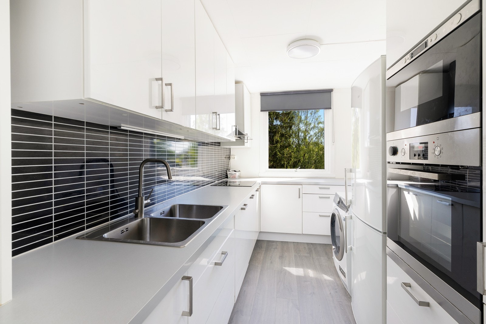 Kjøkken med hvite glatte fronter og laminat benkeplate. Godt med skap og benkeplass. Galleribilde