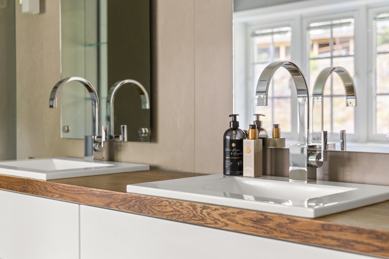 To servanter på benkeplate av tre over servantskap i hvit og glatt utførelse Galleribilde