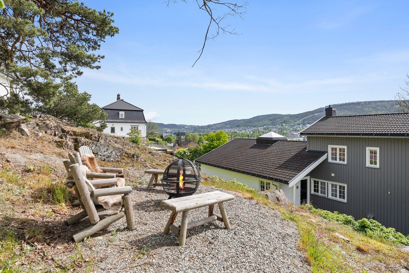 Hyggelig utsiktsområde fra oversiden av tomten som er opparbeidet med en gruset uteplass Galleribilde