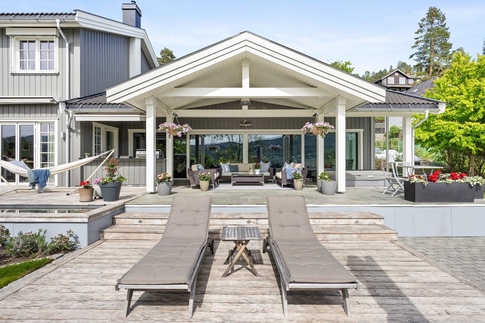 Terrassen ved spaavdelingen er delvis overbygget, har markise, skiferbelagt dekke og nedsenket jaccuzzi Galleribilde