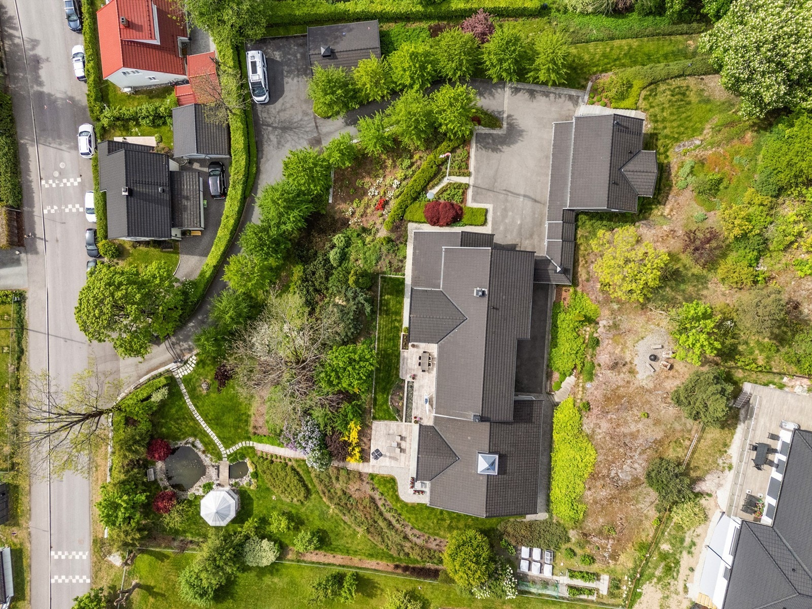 Det er frodige grøntarealer som er godt beplantet med diverse beplantninger i ulike former og farger - etablert automatisk vanningsanlegg i hagen Galleribilde